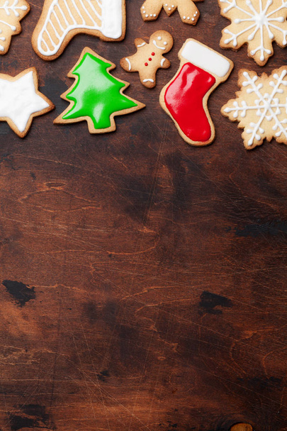 Christmas gingerbread cookies over wooden backdrop. Top view with space for your greetings - Фото, зображення