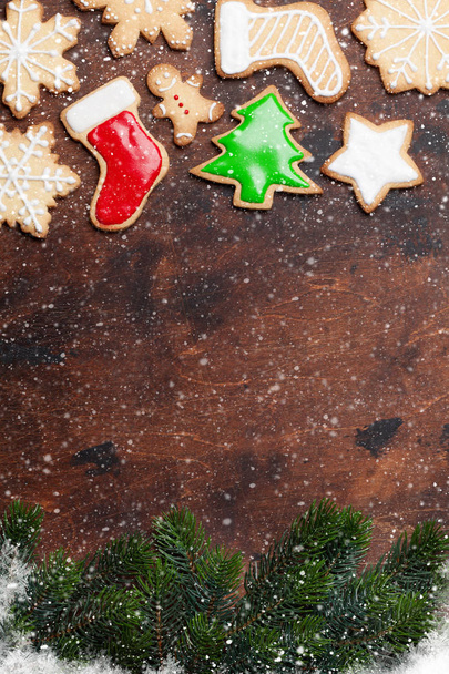 Πλαίσιο κατασκευασμένο με Χριστούγεννα μελόψωμο cookies και Χριστούγεννα έλατα τα κλαδιά σε ξύλινα backdground - Φωτογραφία, εικόνα