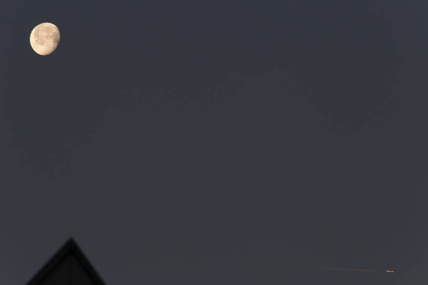 večerní obloha s tmavě modré nebo šedé barevné kontrasty na jasné světlo měsíce někdy letadla vysoko nad fly přes scénu - Fotografie, Obrázek