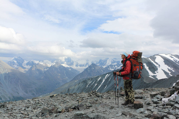 Tourist woman standing on top of the Pass Kara-Turek, against the Belukha Mountain, Altai, Russia - Fotó, kép