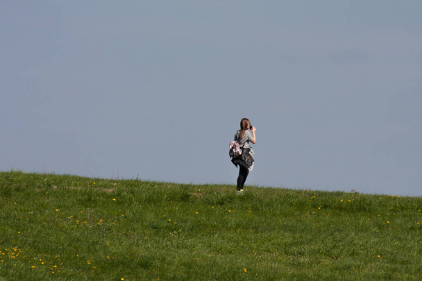 woman walking at springtime by field - Photo, Image