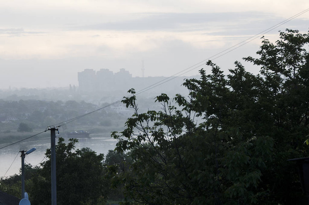 paisagem urbana com um rio no nevoeiro
 - Foto, Imagem
