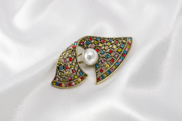 vintage brooch with pearl and colored diamonds isolated on silk - Photo, Image