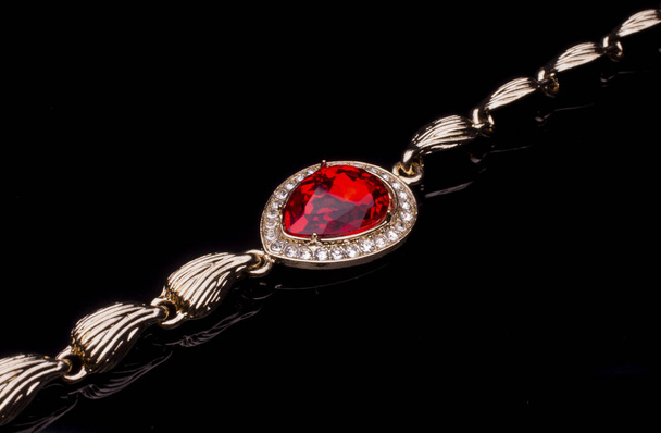 kultainen rannerengas rubiini ja timantteja eristetty musta
 - Valokuva, kuva