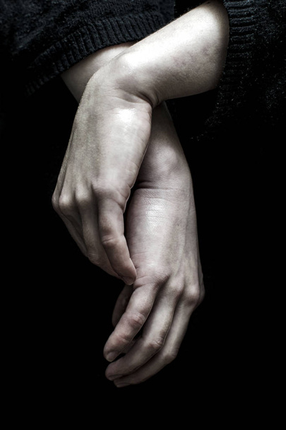 Hands of a young woman isolated on dark background - Foto, afbeelding