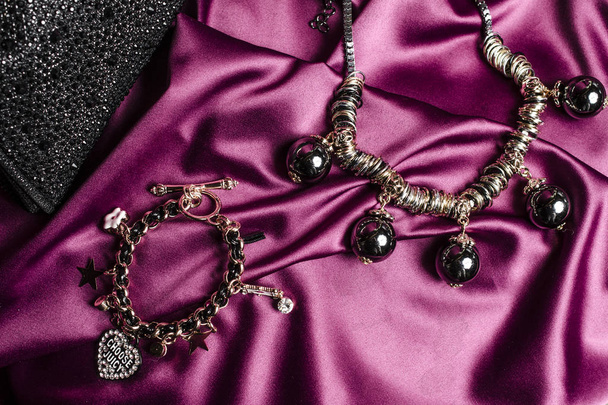 Halskette mit schwarzen Perlen und Armband auf Seidenhintergrund - Foto, Bild