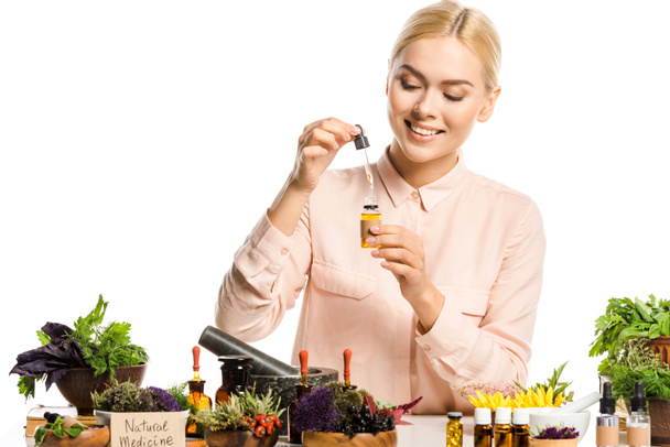 mujer sonriente haciendo aceite esencial aislado en blanco
 - Foto, imagen