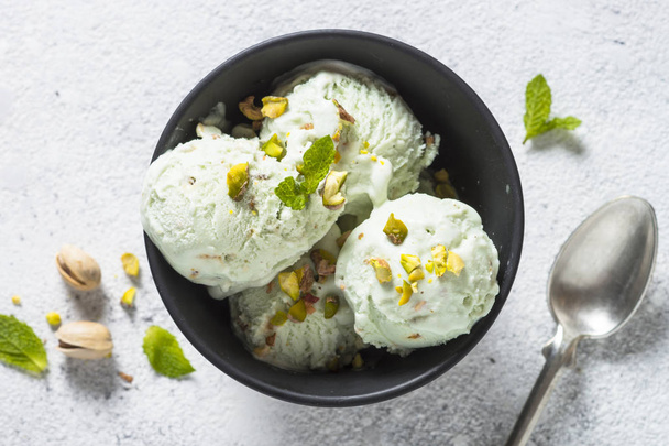 Pistachios ice cream in bowl on white stone table. - Foto, Imagen