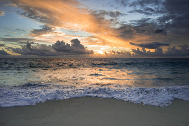 Kaunis auringonlasku rannalla. Pilvinen päivä witn paljon heijastuksia veteen
 - Valokuva, kuva