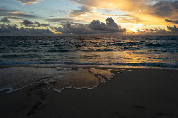 夕陽が美しいビーチ。曇りの日予測に基づく水の反射の多く - 写真・画像