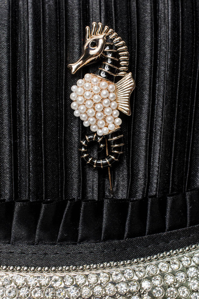 broche de caballito de mar sobre fondo de seda negro con diamantes
 - Foto, Imagen