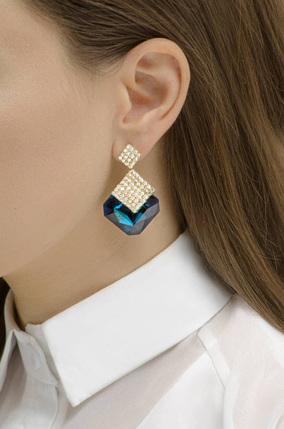 golden earring with gems on the woman's ear - Foto, Imagem