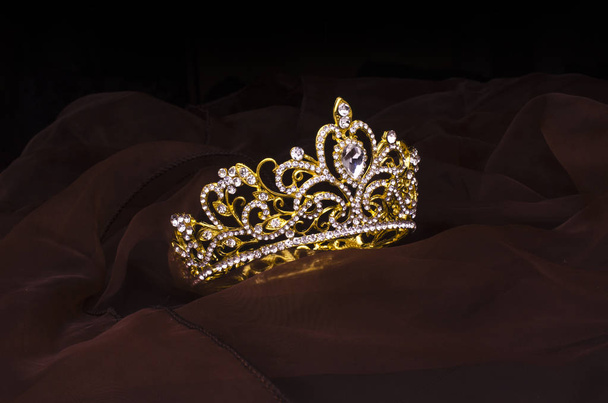 золотая корона с бриллиантами, изолированными на ткани
 - Фото, изображение