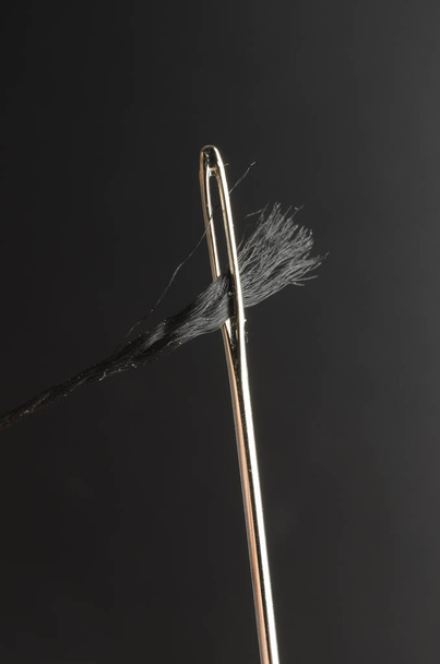 to thread a needle macro isolated on black - Foto, Imagem