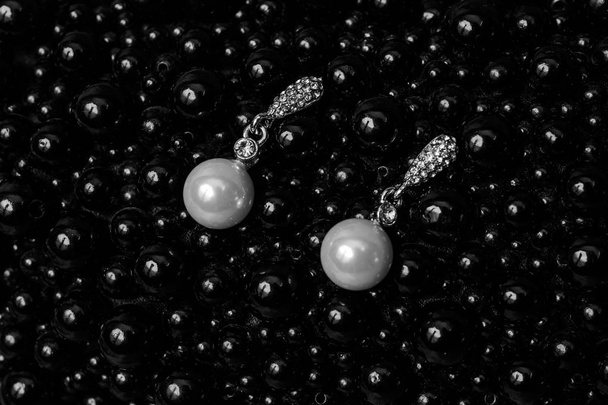 Pendientes con perlas sobre fondo negro
 - Foto, imagen