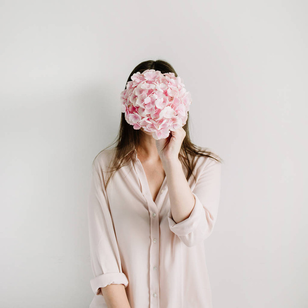 Молода жінка тримає рожевий букет з квітів гортензії на білому тлі. Концепція квіткової моди
. - Фото, зображення