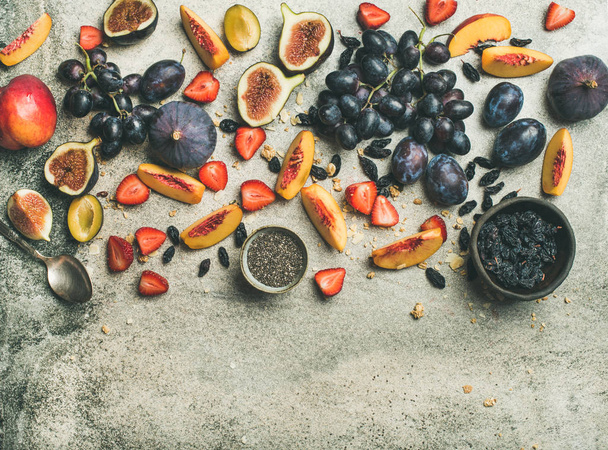 Healthy seasonal fall breakfast variety. Flat-lay of Greek yogurt, fresh fruit, chia seeds over grey concrete background, top view, copy space. Clean eating, dieting, vegetarian food - Foto, afbeelding