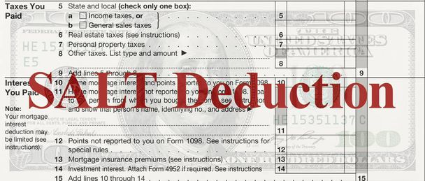 A US Federal tax Schedule A for 1040 income tax form on a 100 dollar bill with text SALT deduction - Photo, Image
