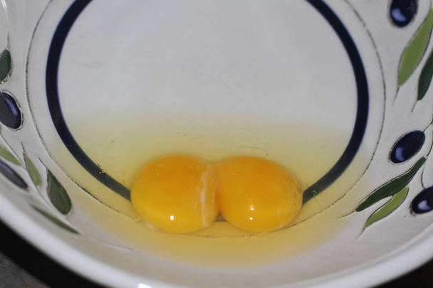 Raw eggs with yolks and whites in a bowl - Photo, Image
