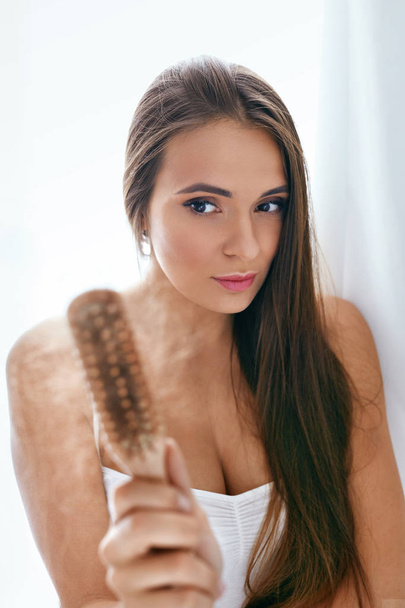Pérdida de cabello. mujer molesta sosteniendo cepillo con pelo
 - Foto, Imagen