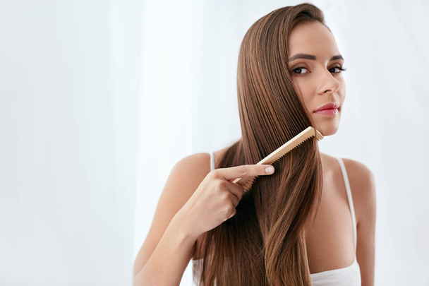 Hair Care. Woman Combing Beautiful Long Hair With Wooden Brush - Valokuva, kuva