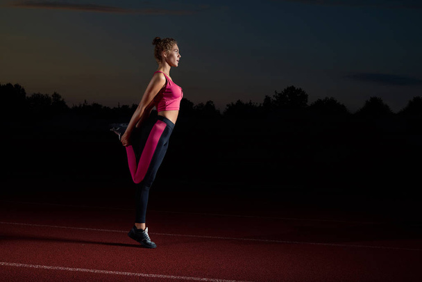 Спортивная женщина делает растяжку для ног после бега
. - Фото, изображение