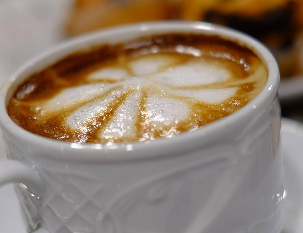 a coffee served with white foam decoration - Photo, Image