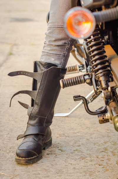 foot of a biker girl in a motorcycle boot sitting on a motorcycle - Photo, Image
