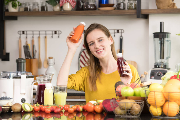 Mujer joven y saludable en una cocina con frutas y verduras y jugo
 - Foto, imagen