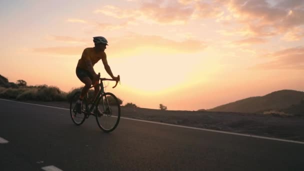 Ο αθλητής με ποδήλατο πηγαίνει από ένα βράχο σε ένα βουνό σερπεντίνη βλέπουν μια όμορφη θέα του νησιού. Η έννοια ενός υγιεινού τρόπου ζωής. Τουριστικά ταξίδια με το ποδήλατο - Πλάνα, βίντεο