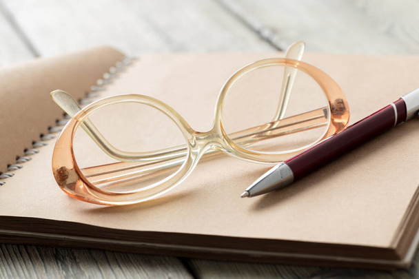notepad and eyeglasses on the table - Φωτογραφία, εικόνα