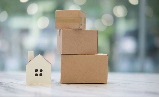 Cajas de cartón y hogar en miniatura, concepto de negocio de servicio para mover nuevo hogar
 - Foto, imagen