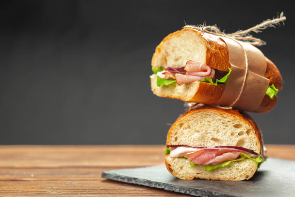 close up of tasty sandwiches on a wooden table - Foto, imagen