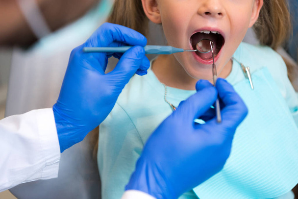 περικοπεί shot του οδοντιάτρου να εξετάσει τα δόντια μικρού παιδιού - Φωτογραφία, εικόνα