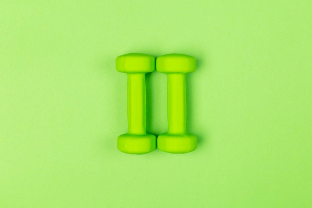 two green dumbbells, fitness concept - Foto, Imagem