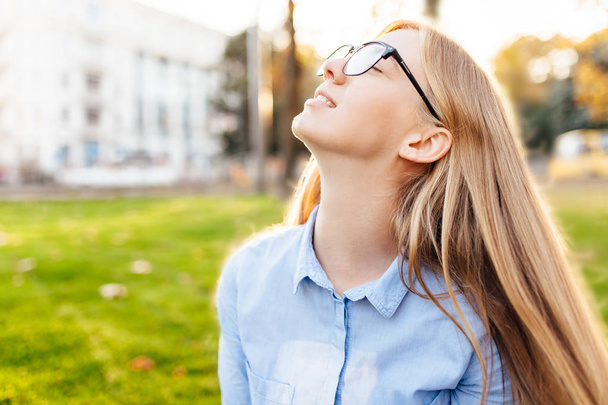 happy girl with glasses breathe fresh air, enjoy the warmth, outside - Zdjęcie, obraz