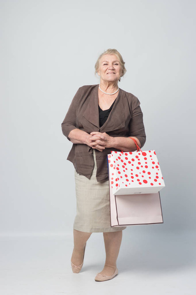an old woman holding shopping bags - Photo, image