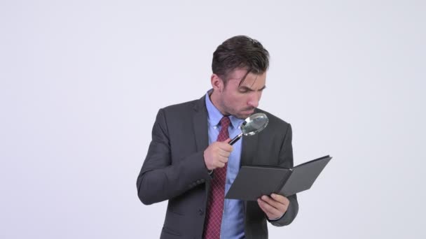 Studio shot of young handsome Hispanic businessman wearing suit against chroma key with white background - Πλάνα, βίντεο