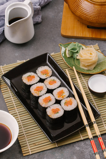 Rollos tradicionales de sushi japonés servidos con jengibre y wasabi picante
  - Foto, imagen