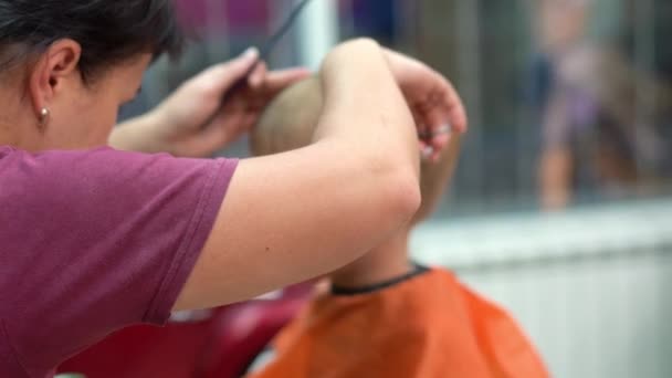 fryzura małego chłopca w salon fryzjerski dla dzieci - Materiał filmowy, wideo