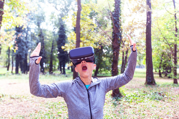 Сюрприз Старшая женщина весело с гарнитурой виртуальной реальности в лесу, устройство виртуальной реальности с использованием пожилых людей
. - Фото, изображение