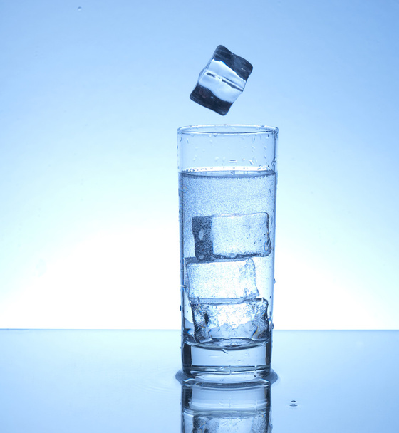 Ice cube and glass of water - Φωτογραφία, εικόνα