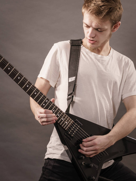 Man playing on electric guitar during gig. Musical instrument. Teenage boy having music hobby. - Fotó, kép