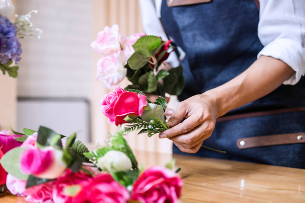 Układanie kwiatów sztucznych kamizelka ozdoba w domu, młoda kobieta Kwiaciarnia pracy, co organizowanie diy Sztuczny kwiat, rzemiosło i rękodzieło koncepcja. - Zdjęcie, obraz
