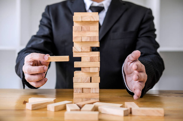 Alternative risk concept, plan and strategy in business, Risk To Make Business Growth Concept With Wooden Blocks, Images of hand of business people placing and pulling wood block on the tower. - Foto, afbeelding