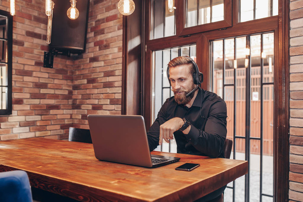 İşveren görüntülü görüşme yoluyla online görüşme sırasında konuşurken kulaklık ile uzman Genç sakallı - Fotoğraf, Görsel
