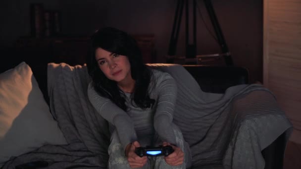 woman playing videogame on console and wins. Sitting on sofa at home - Materiał filmowy, wideo