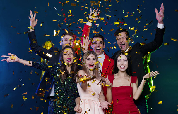 Grupo de amigos felizes celebrando o ano novo com confete dourado
  - Foto, Imagem