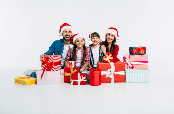 Young happy family with pile of christmas presents on white background - Foto, Imagem