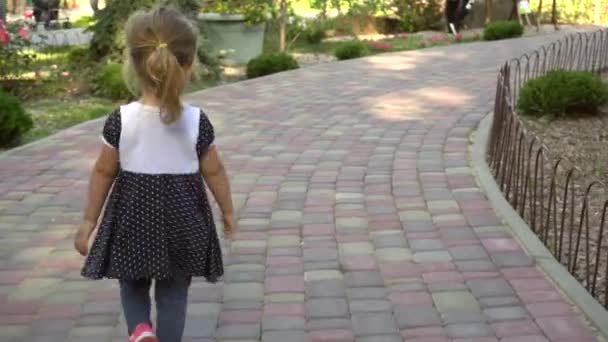 Anonymous girl walking along path in park - Filmati, video